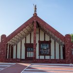 Vibrant Māori Meeting House in New Zealand with traditional carvings and architecture.